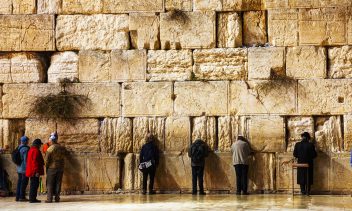 JERUSALEM - DECEMBER 15: The Western Wall in the night with a praying pilgrims on December 15, 2013 in Jerusalem. It's located in the Old City of Jerusalem at the foot of the western side of the Temple Mount.